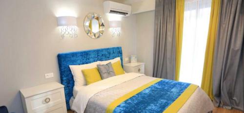 - une chambre avec un lit bleu et jaune et une fenêtre dans l'établissement LUXE GAMBETTA - SEA VIEW, à Nice