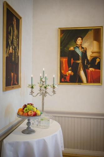a table with a plate of fruit and a painting at Eksjö Stadshotell in Eksjö