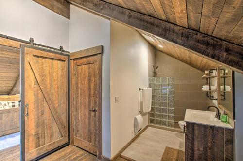 a bathroom with a wooden door and a sink at Shared Game Room Dazzling Cle Elum Home in Ronald