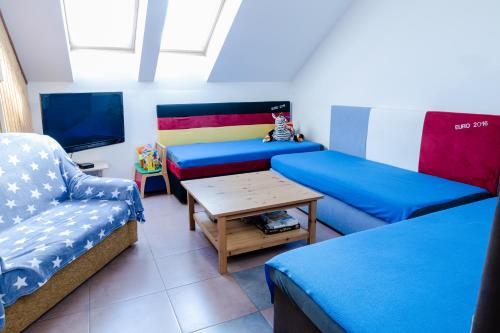 Pokój z dwoma łóżkami, stołem i telewizorem w obiekcie APARTMÁN CABERNET w mieście Velké Pavlovice