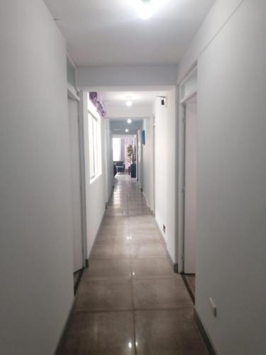 an empty hallway with white walls and a long floor at Cusco Cozy Apartment in Cusco