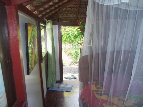 a view from inside a room with a curtain at Pension Te Nahetoetoe in Parea