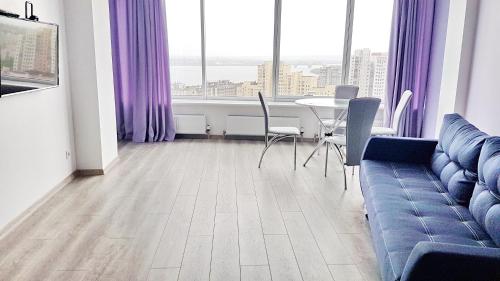 a living room with a couch and a table with chairs at Most City Apart-Hotel in Dnipro