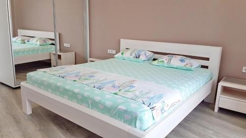 a bedroom with a white bed and a mirror at Most City Apart-Hotel in Dnipro