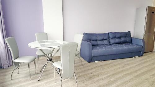 a living room with a couch and a table and chairs at Most City Apart-Hotel in Dnipro