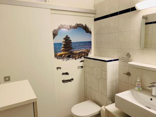 een badkamer met een muur met een foto van een man bij Ferienwohnung 258 Haus Schleswig in Kalifornien