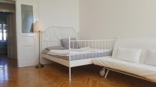 Room next to Porto Montenegro في تيفات: سرير أطفال أبيض في غرفة بها مصباح