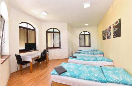 a room with four beds and a desk and a computer at penzion Za lávkami in Dačice