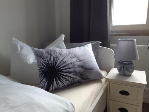 a bed with a pillow and a lamp on a night stand at Pension Zur Alten Post in Havelberg