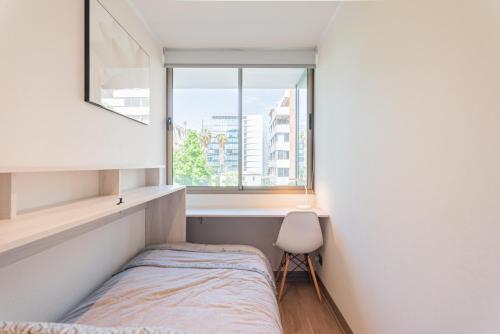 een kleine slaapkamer met een bed en een raam bij Luxury Retreat w/ 2BR, Wifi, Pool, Gym in Santiago