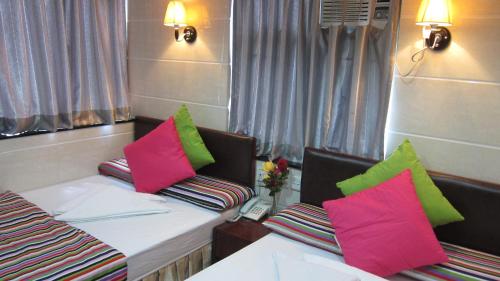 a room with two couches with pink and green pillows at Australia Lounge in Hong Kong