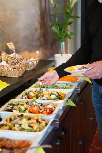 a buffet line with many trays of food at Eksjö Stadshotell in Eksjö