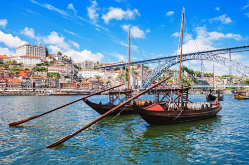 two boats in the water in front of a bridge at Casa de Praia Guest House in Labruge