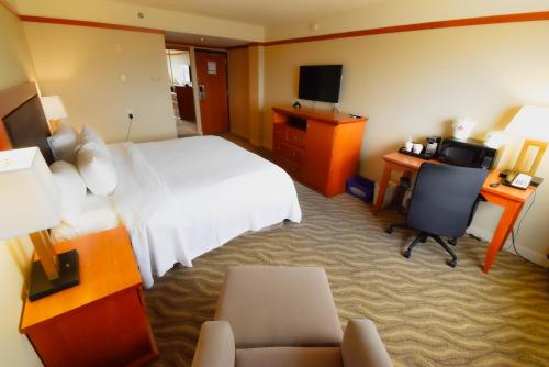 a hotel room with a bed and a desk and a television at Canad Inns Destination Centre Polo Park in Winnipeg