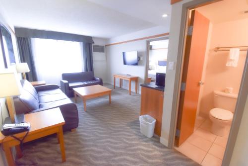 a hotel room with a couch and a living room at Canad Inns Destination Centre Polo Park in Winnipeg