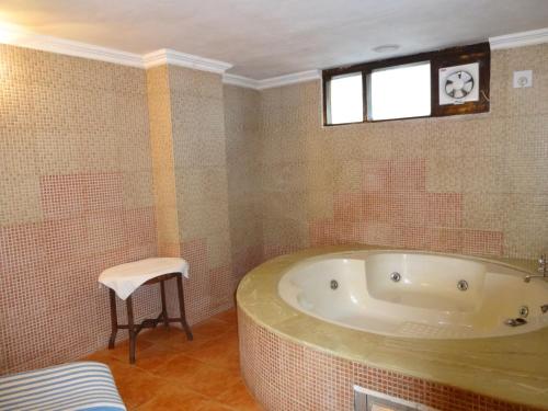 a bathroom with a tub and a stool in it at Hotel Combermere in Shimla