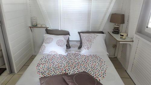 a small room with a bed with pillows on it at TI-MANGO VUE MER in Sainte-Anne