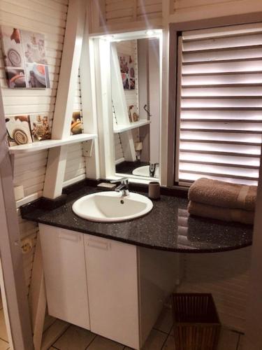 a bathroom with a sink and a mirror at TI-MANGO 1km de la plage communale quartier résidentiel in Sainte-Anne