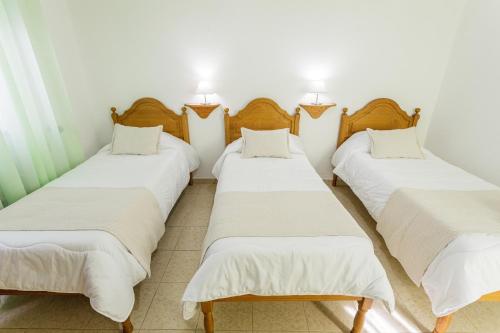 a group of four beds in a room at Hospedaria Australia in Velas