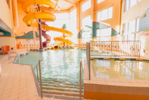 a swimming pool with a water slide in a building at Canad Inns Destination Centre Polo Park in Winnipeg