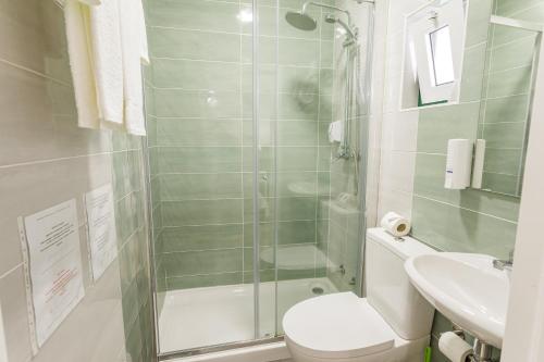 a bathroom with a shower and a toilet and a sink at Hospedaria Australia in Velas