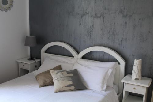 a bedroom with a white bed with white pillows at Alle Terme B&B in Rapolano Terme