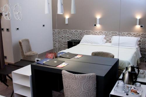 a hotel room with a bed and a table and chairs at Hotel Berna in Milan