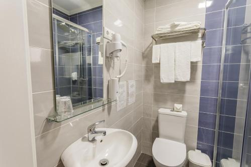 a bathroom with a white toilet and a sink at Hospedaria Australia in Velas