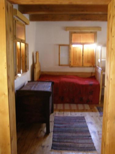 1 dormitorio con cama roja y armarios de madera en Casa Emma Ház, en Sovata