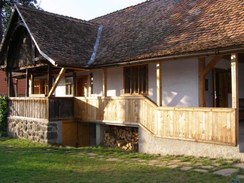 una casa con una terraza de madera en un lateral en Casa Emma Ház, en Sovata