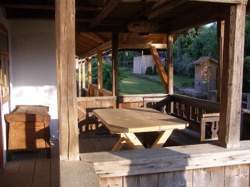 a wooden porch with a picnic table on a deck at Casa Emma Ház in Sovata