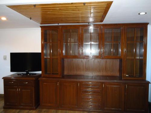 a large wooden entertainment center with a flat screen tv at Hotel Combermere in Shimla