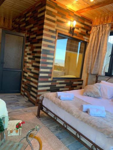 a bedroom with two beds in front of a brick wall at Harsnadzor Eco Resort in Halidzor