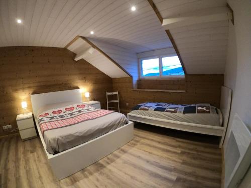 a bedroom with two beds in a attic at Chez Léa et Lolo - L'Alpina in Gérardmer