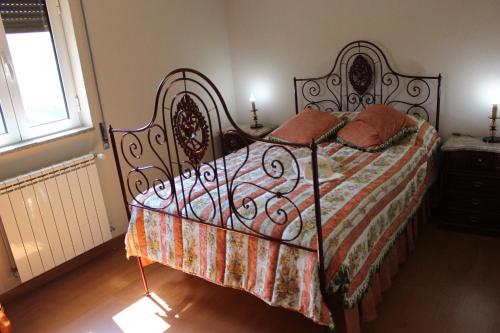 a bedroom with a bed with a wrought iron frame at Casa do Passarinho in Resende