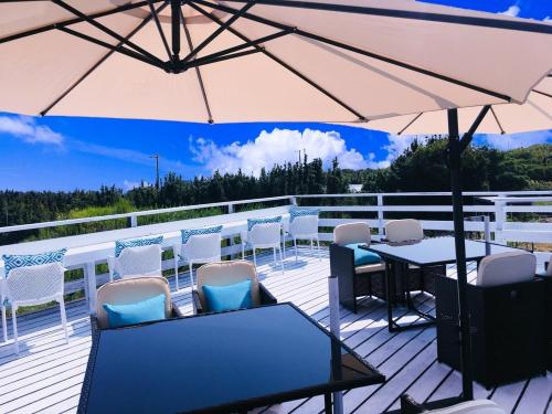 a deck with a table and chairs and an umbrella at GRAN BLUE - Vacation STAY 11224v in Minamiboso
