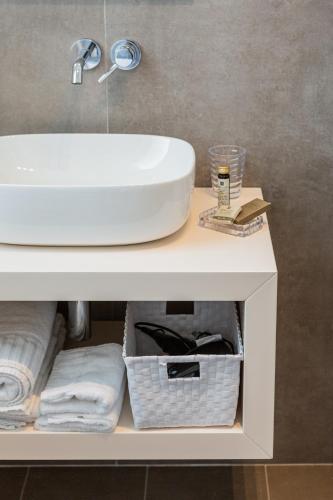 a bathroom sink on top of a white table with towels at B&B PREVISTO SOLE in Civitanova Marche
