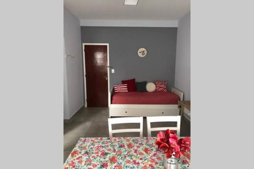 1 dormitorio con cama roja y mesa en Hermoso departamento a la calle a 300 mts del mar en Mar del Plata