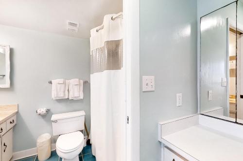 a white bathroom with a toilet and a shower at Beach Escape Condos in Daytona Beach Shores