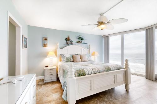 a white bedroom with a bed and a window at Beach Escape Condos in Daytona Beach Shores