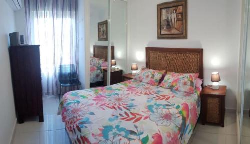 トロクス・コスタにあるLaguna Beachのベッドルーム1室(花柄のベッドカバー付きの大型ベッド1台付)
