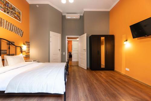 a bedroom with a bed and a flat screen tv at Post House Rooms in Lviv