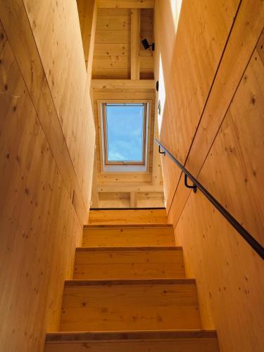 a staircase in a tiny house with a window at Ferienhaus Königsdorf - Urlaub im Tölzer Land in Königsdorf