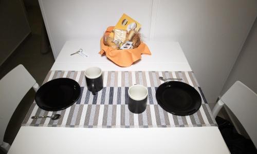 a white counter with two cups and a bag on it at Domus Flò in Santa Maria di Castellabate