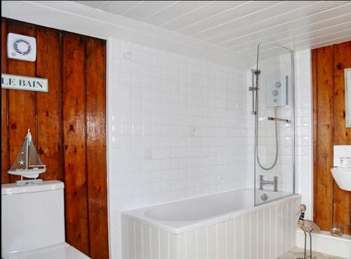 a bathroom with a tub and a toilet and a sink at Charming original fishermans cottage on Dungeness beach in Dungeness