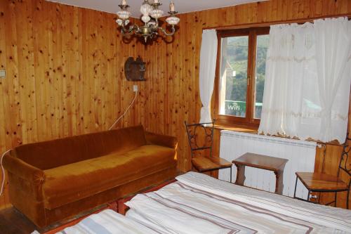 a bedroom with a couch and a bed and a window at Tara Bridge Castle in Žabljak
