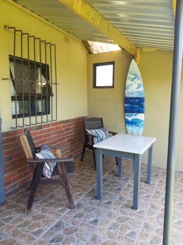 - une table et deux chaises sur la terrasse dans l'établissement Ocean rush turtle, à Zinkwazi Beach