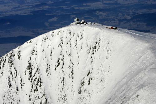 a snow covered mountain with people on top of it at Za řekou in Mladé Buky