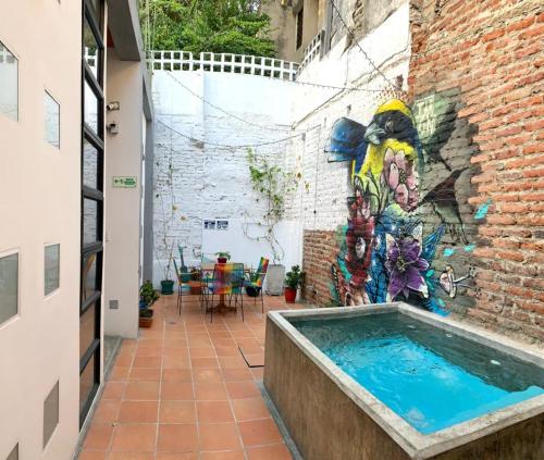 a swimming pool in a brick building with a mural at Imagine hostel in Santa Marta