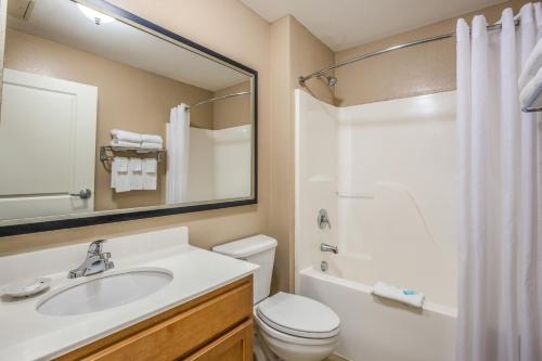 a bathroom with a sink and a toilet and a mirror at MainStay Suites Port Saint Joe in Port Saint Joe